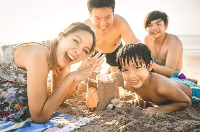 Chinese family of four on beach.